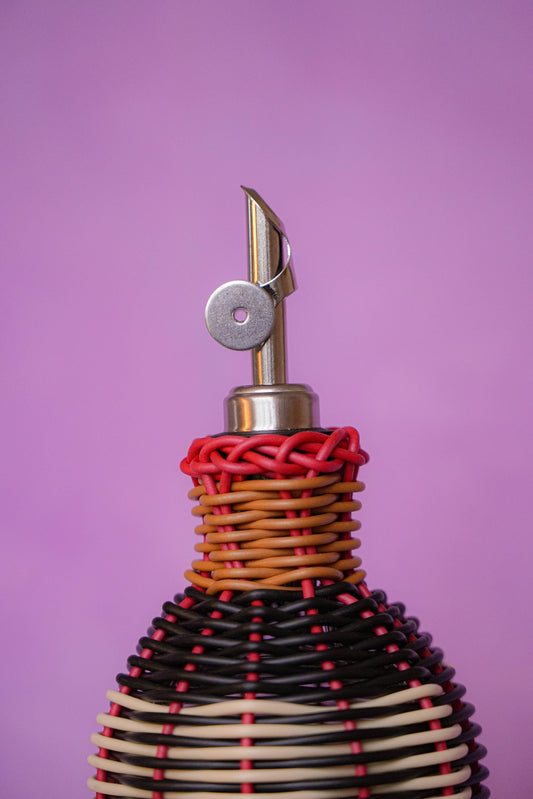 MÆGEN hand-woven glass oil pourer in black and cream with stainless steel pourer top